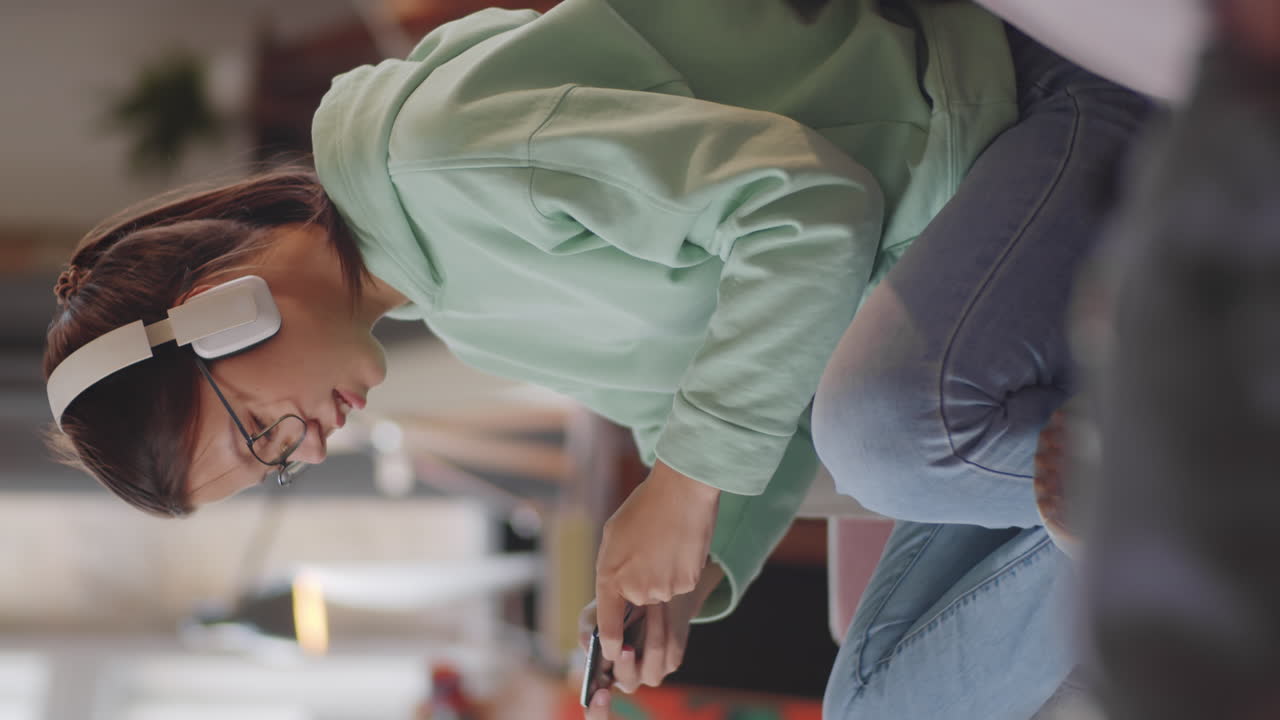 Teen Girl in Headphones Playing Game on Mobile Phone
