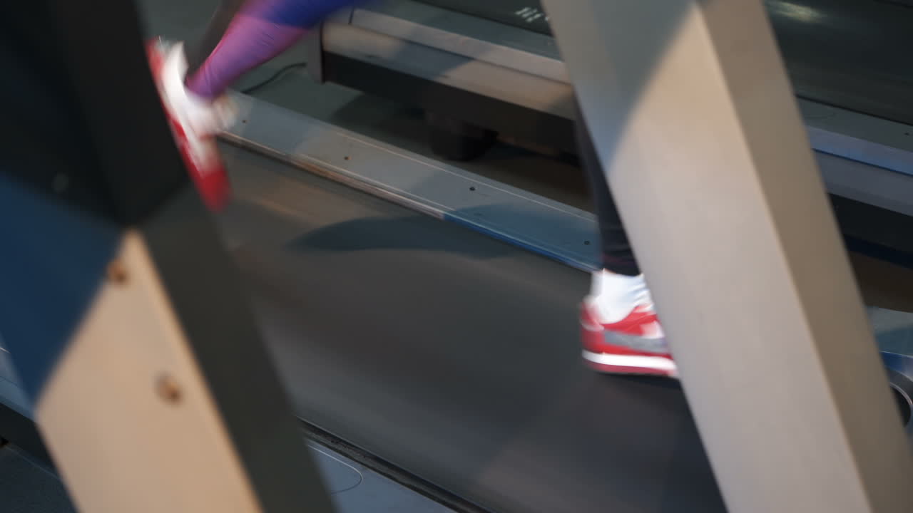 Beautiful athletic woman running on a treadmill at the gym. The ideal female figure. Cardio training