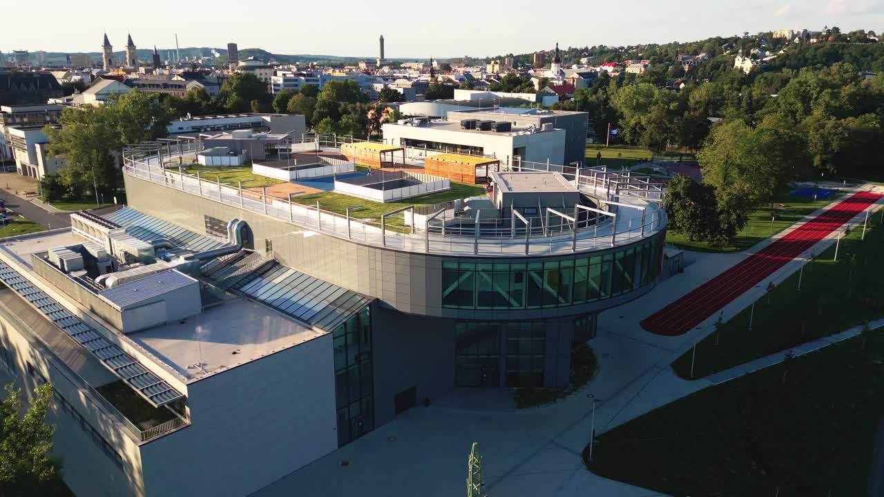 vista aérea del moderno edificio del campus con una pista de carrera oval en el techo