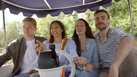 group of friends enjoying day out in boat on river together