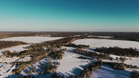 a stunning drone shot capturing the morning countryside blanketed in fresh snow after a rare snowfall in south georgia. slow push-in movement.