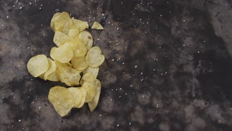 vista de cerca de la sal sobre las papas fritas con espacio de copia en la superficie negra