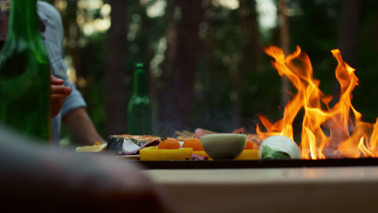hombre irreconocible preparando barbacoa para una fiesta afuera. pescado y verduras marrones