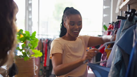 two friends shopping for clothes in fashion store together