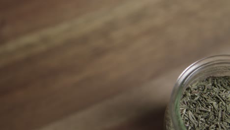 Medium-close-shot-of-dried-thyme-sitting-in-a-small-glass-jar