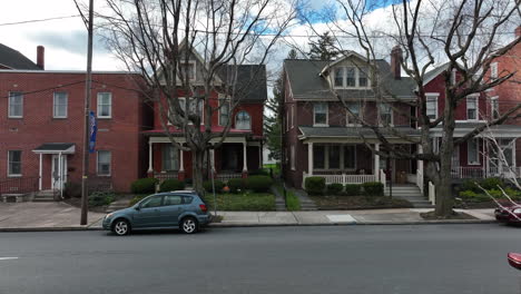 rising aerial reveals traditional homes in small town in pennsylvania, united states, welcome friends and family