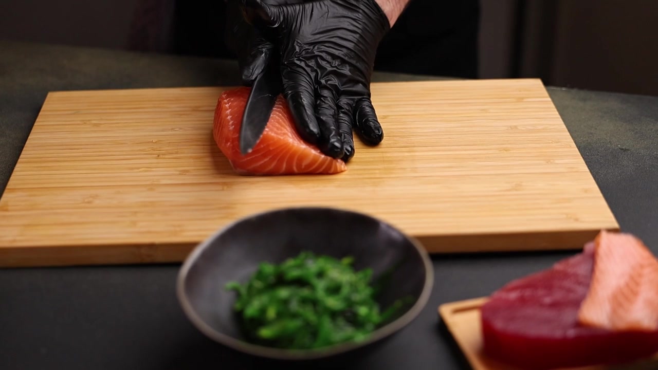 Chef in Black Gloves Prepares Fresh Salmon Fillet