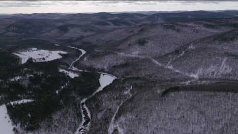 Antena-Escénica-Dron-Adelante-Movimiento-Canadiense-Desierto-Mediados-De-Invierno-Cerca-Del-Norte-De-Quebec-Stoneham-Ski-Resort-Of-Frozen-Over-Sautaurski-River-Río-Arriba-Parque-Nacional-Jacques-Cartier