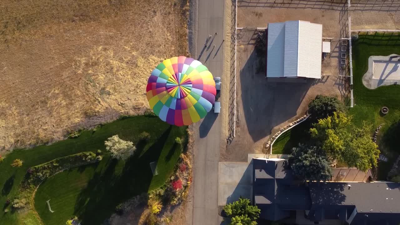 vista de drones de un hermoso globo aerostático aterrizando en un campo