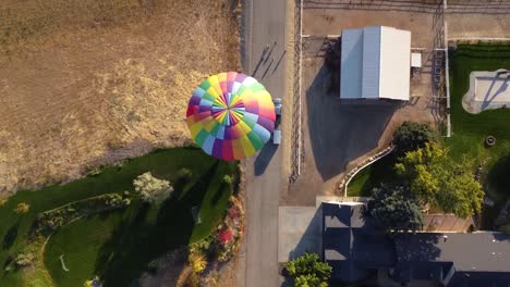 Vista-De-Drones-De-Un-Hermoso-Globo-Aerostático-Aterrizando-En-Un-Campo