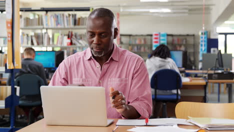 Estudiante-Varón-Maduro-Trabajando-En-Una-Computadora-Portátil-En-La-Biblioteca-De-La-Universidad