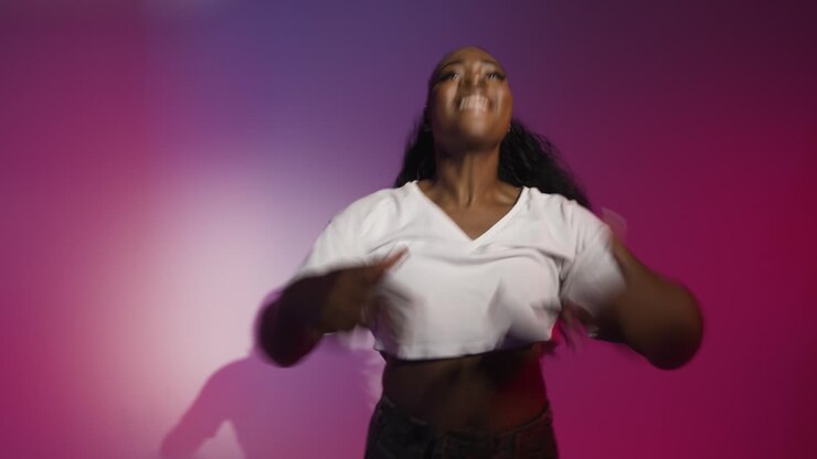 Studio Shot Of Young Woman Dancer Dancing Against Blue And Pink Lit Background 11