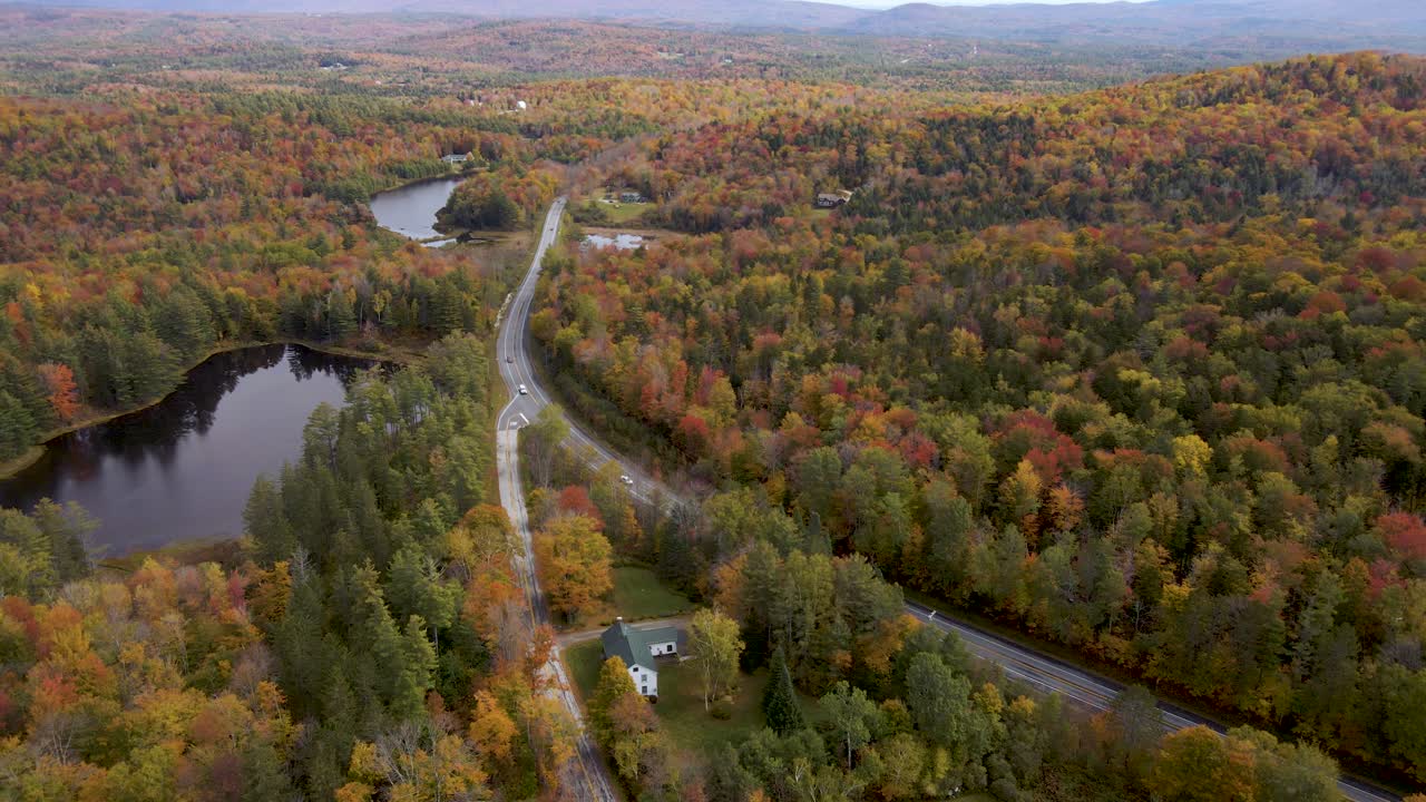 vista aérea épica sobre la interestatal de nueva inglaterra con un hermoso bosque de colores otoñales