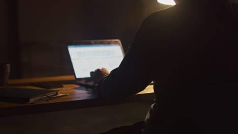 hombre anónimo sentado en su escritorio en el estudio de la oficina trabajando en una computadora portátil por la noche. hombre trabajando con datos, analizando estadísticas. 360 grados de seguimiento de movimiento de tiro de arco