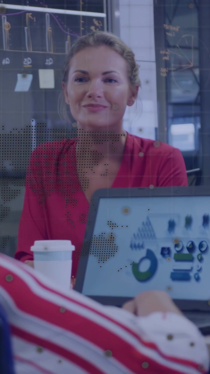 Vertical video: Woman smiling listening in biz chat while peer tapping laptop causing charts moving