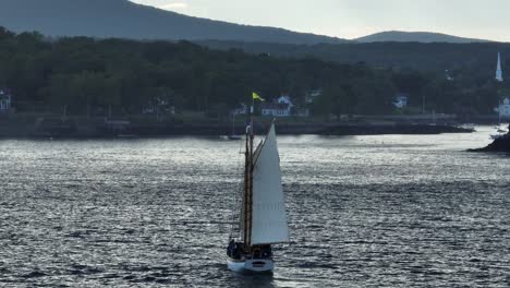 traditional wooden sailboat sailing into camden harbor