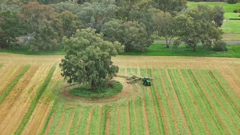 aerial view of tractor harvesting hay in a field