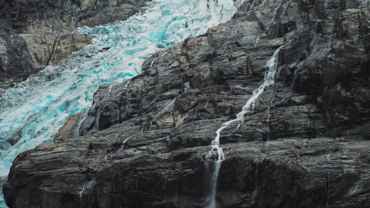 Una cascata sulle pendici rocciose del ghiacciaio Kjenndalsbreen
