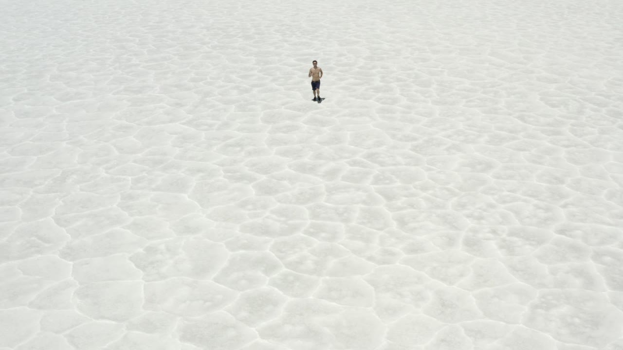 imágenes de drones de un hombre corriendo en salinas en el valle de la muerte, california