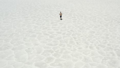 Drone-footage-of-a-man-running-on-salt-flats-in-Death-Valley,-California