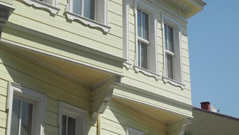 a yellow wooden house with white windows