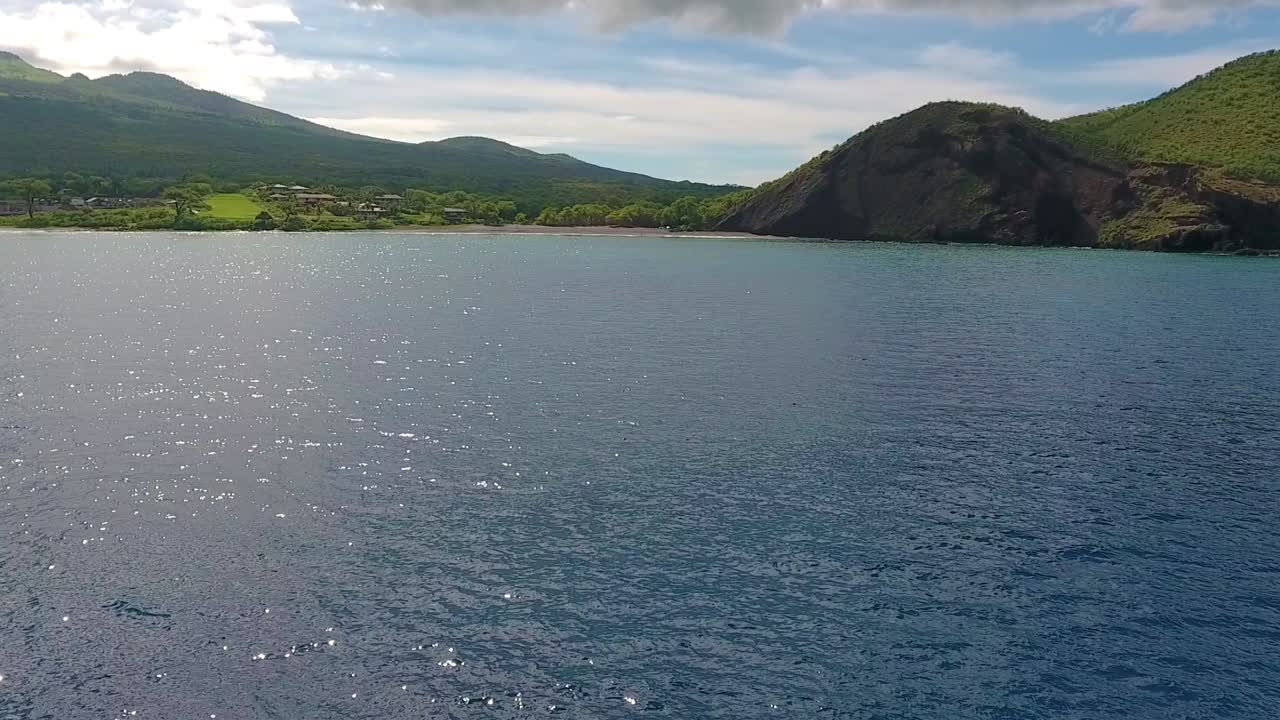 Aerial shot of beautiful beach shore with a cloudy sky in the background.