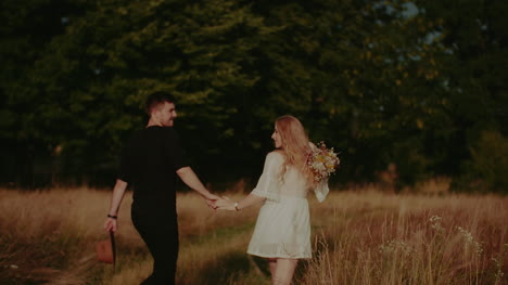 boho couple walk in forest in summer 2