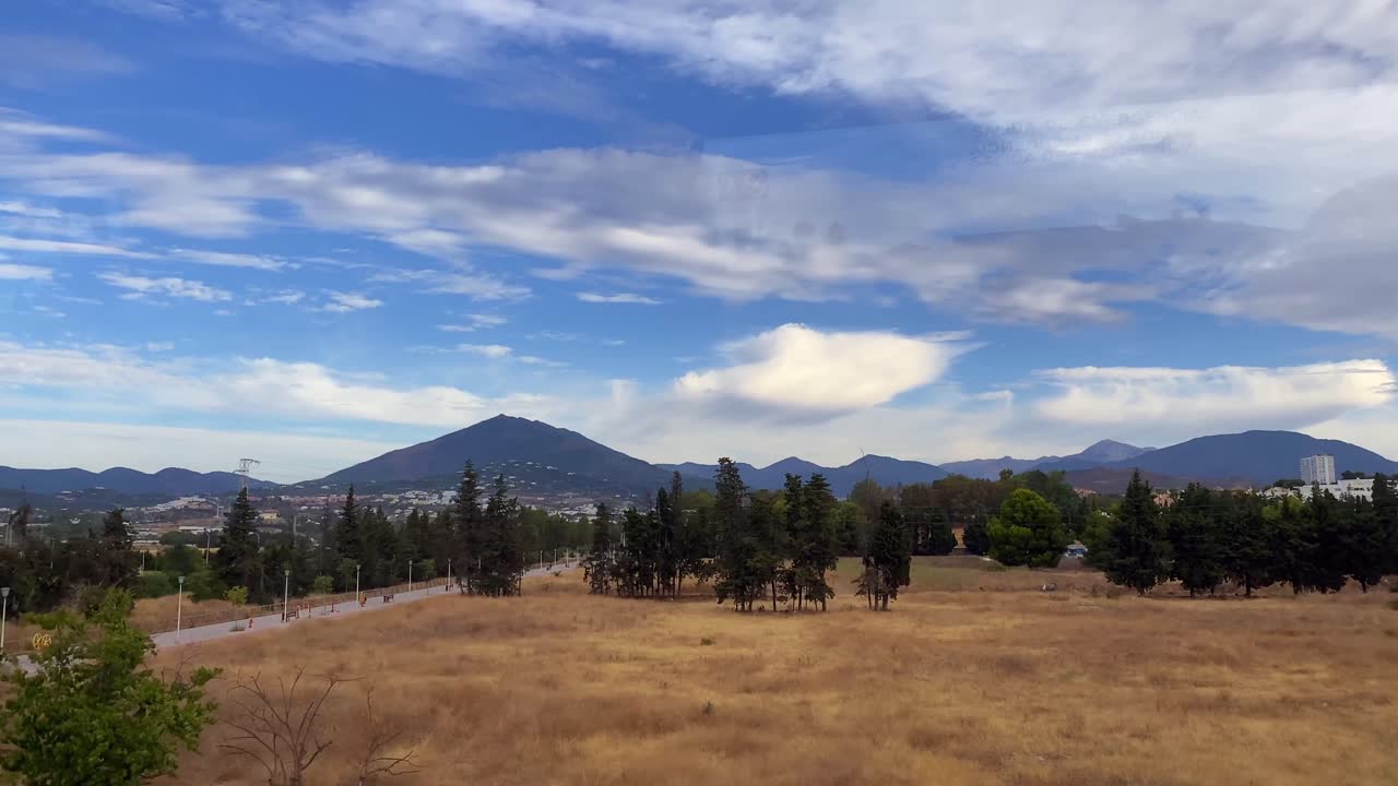Riprese di un paesaggio con campi e colline da un treno in Spagna.