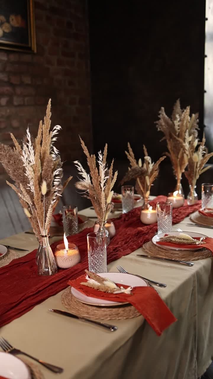 Mesa de comedor elegante decorada con hierba de la Pampa y velas encendidas