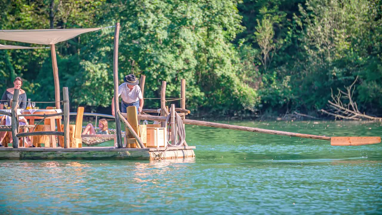 Slow motion shot of a raftsman rowing with a long wooden oar in a traditional Slovenian raft