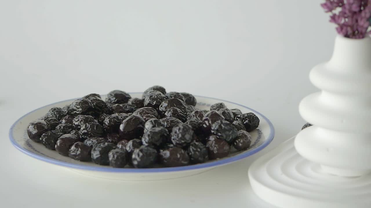 primer plano de aceitunas negras en un plato