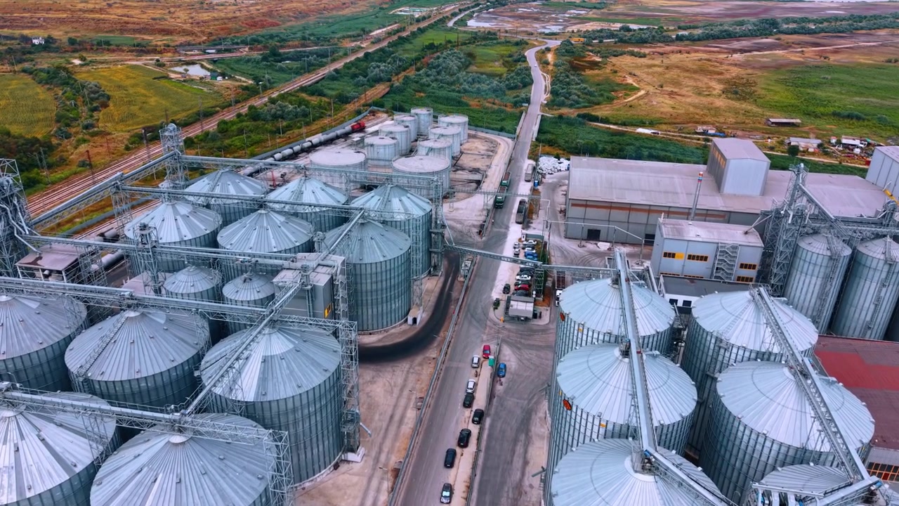 Grande instalação de armazenamento de grãos com silos perto de uma estrada rural. Vista aérea de uma área de armazenamento de grãos mostrando muitos silos e uma estrada próxima em uma localização rural.