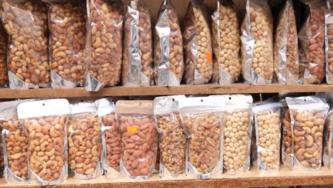 assortment of nuts in bags on wooden shelves