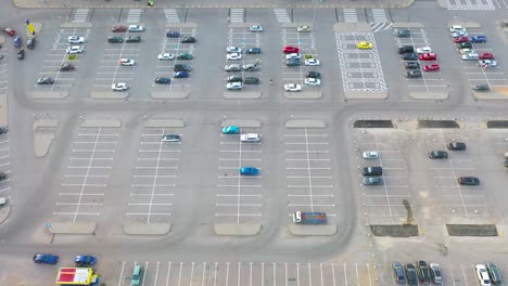 aerial top down view of the parking lot with many cars of supermarket shoppers in the city grocery store