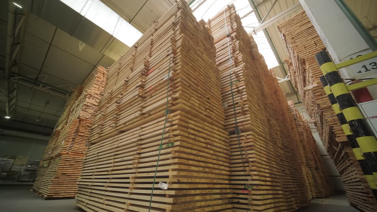 Large Stacks of Wooden Planks Stored in Industrial Warehouse