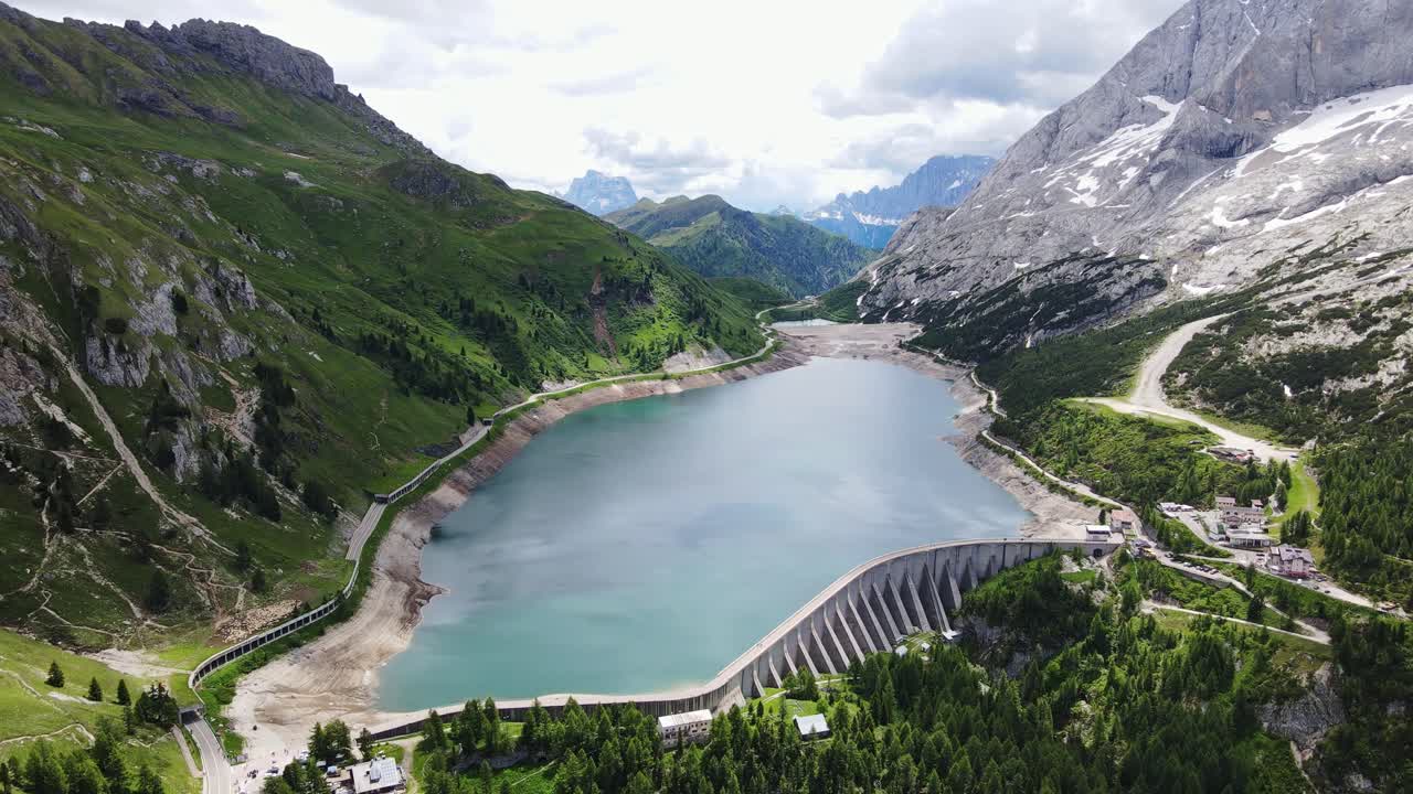 Scenic aerial panorama captures serene lake and dam in Trentino alpine region