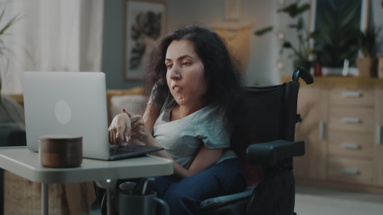 mujer en silla de ruedas usando una computadora portátil
