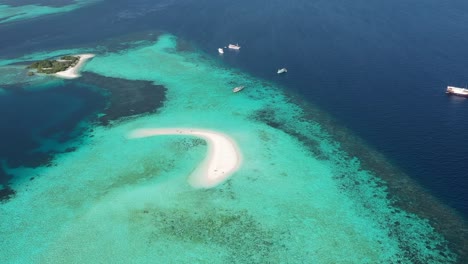 Excelente-Toma-Aérea-De-Turistas-Y-Pequeñas-Lanchas-Motoras-Cerca-De-La-Isla-De-Arena-En-El-Parque-Nacional-De-Komodo-En-Indonesia