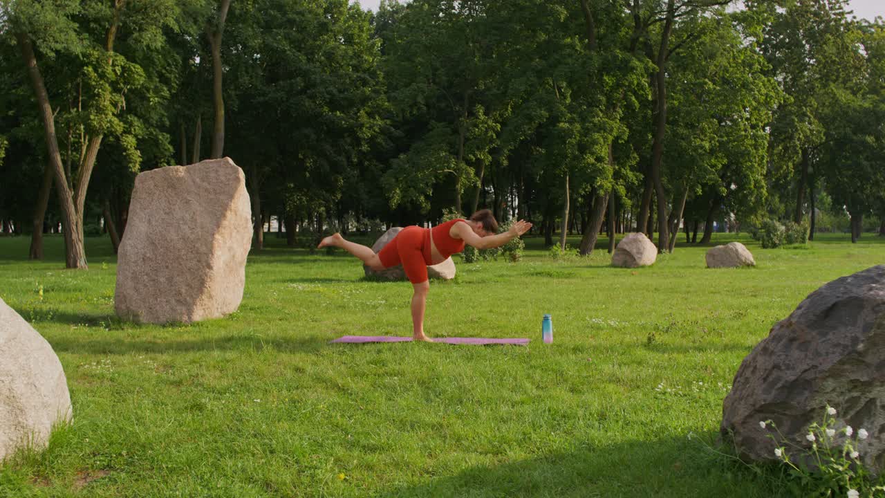mujer practicando yoga en un parque