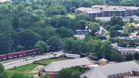 Aerial-footage-of-heavy-freight-train-passing-through-turn-in-suburbs