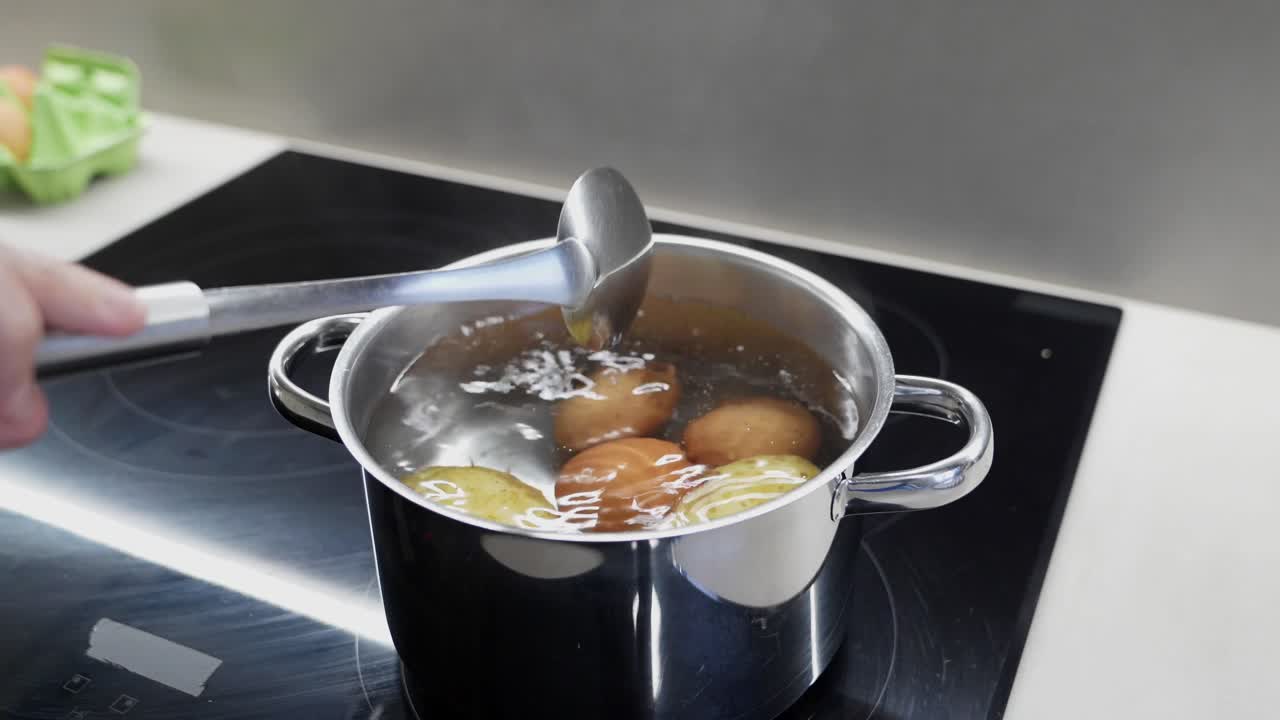 Boiling Eggs and Potatoes in a Pot on a Kitchen Stove