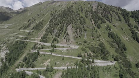 Reverse-plane-drone-video-over-meandering-climb-of-the-stelvio-pass