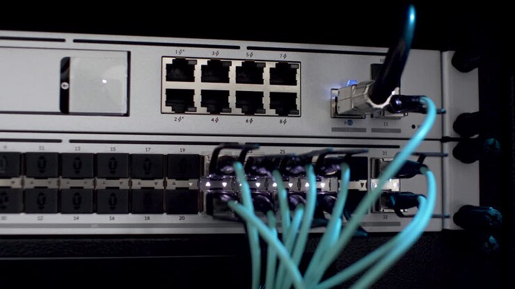LAN and Fibre Optic Cables Plugged In Network Server Rack With White Blinking Lights