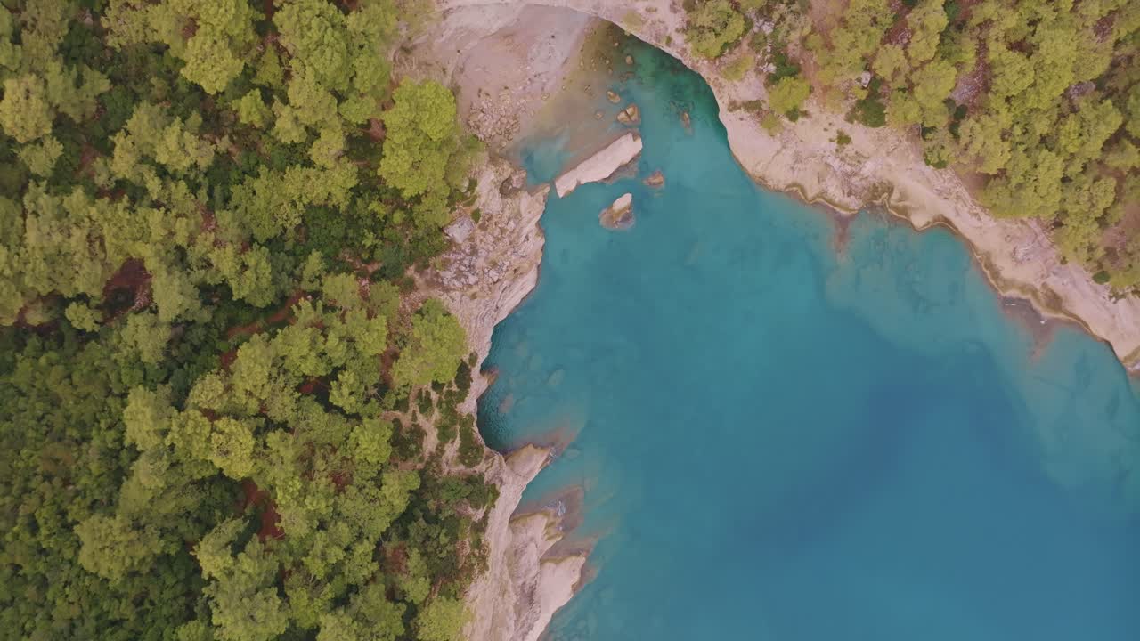 Vista Aerea di un Lago Turchese e una Foresta Rigogliosa