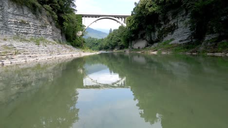 shot with fast forward movement under a river with a bridge in the distance