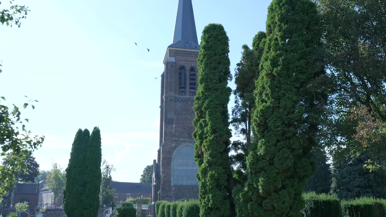 A church surrounded by trees and a cemetery