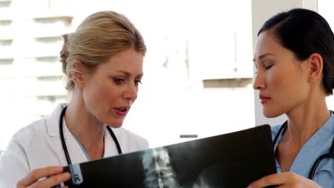 el médico y la enfermera miran las radiografías.