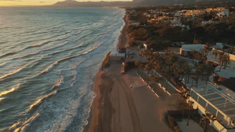 Vista-Aérea-De-La-Playa-Vacía-Moviéndose-Lentamente-Hacia-Atrás-E-Inclinándose-Hacia-El-Horizonte