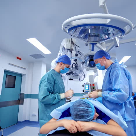 two neurosurgeons perform a spinal surgery on a patient inside the operating room. spinal surgery in the neurosurgical department of the hospital using modern medical instruments.