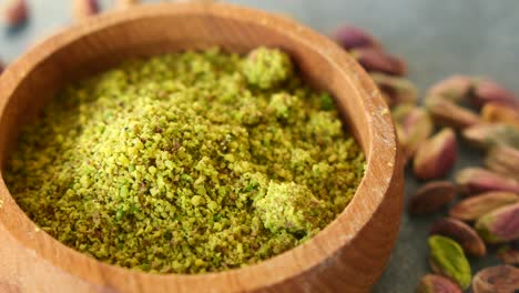 close up of pistachio powder in a wooden bowl